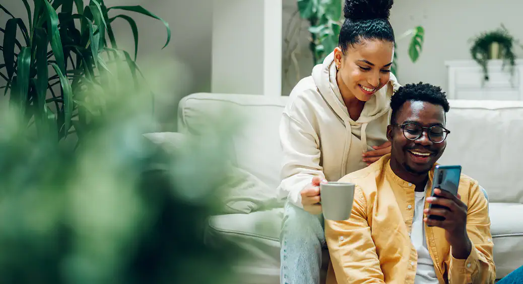 Happy couple relaxing at home with coffee